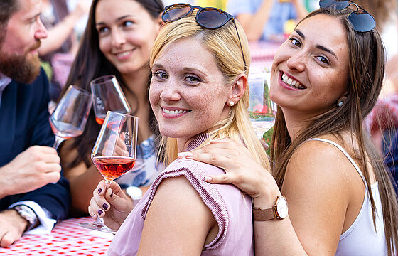 Zwei junge Frauen trinken vergnügt Wein