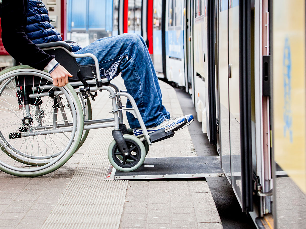 Mann in Rollstuhl steigt in Bahn ein